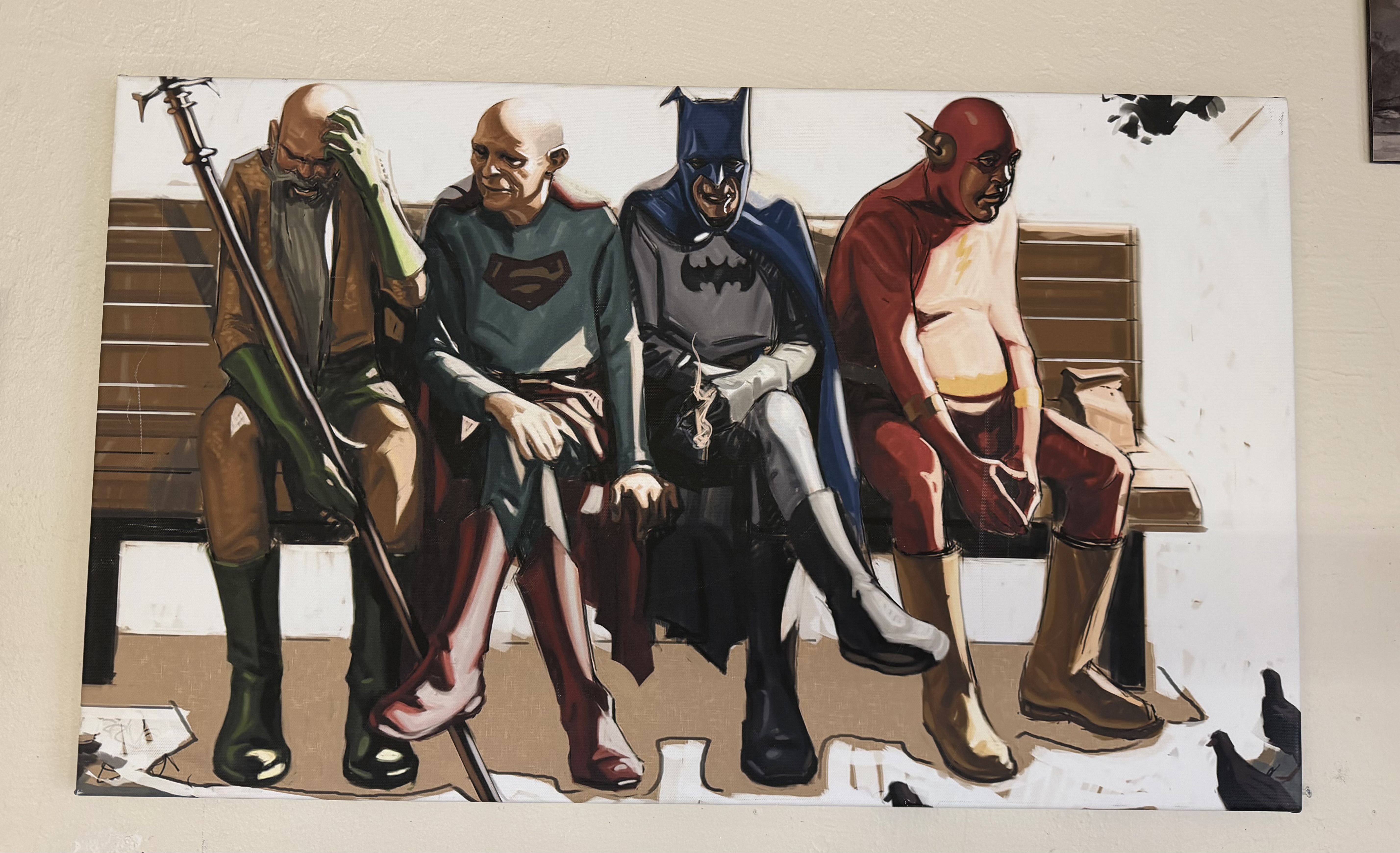 Framed superhero-themed artwork on display at Village Barber Shop